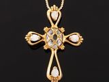 an 18k gold cross pendant with oplites and diamonds