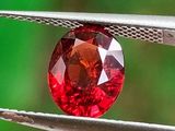 a close up of a red diamond being held by a pair of pliers