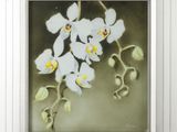 painting of white orchids in a white frame on a wall