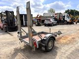 a trailer with a fork attached to it in a parking lot