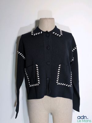 un mannequin vêtu d'une veste noire à rayures blanches