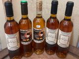 several bottles of wine are lined up on a wooden tray