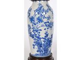 un grand vase bleu et blanc posé sur un socle en bois, sur fond blanc