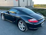 La voiture de sport noire est garée sur le bord de la route.