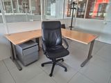 a black office chair sitting in front of a wooden desk