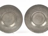 une paire de plats plaqués argent posés sur des supports, disposés sur un fond blanc