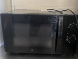 a black microwave sitting on a counter in a kitchen