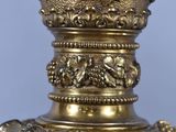 a vase that has a gold decoration on the top of it
