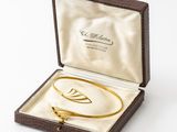 an image of a gold bracelet in a box on a white background