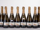 six bottles of champagne lined up in a row on a white surface