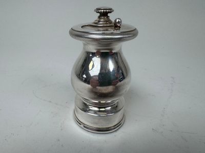 un petit objet en argent posé sur une table
