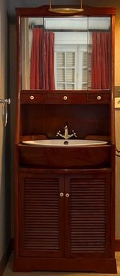 une salle de bains équipée d'un lavabo, d'un miroir et d'une armoire