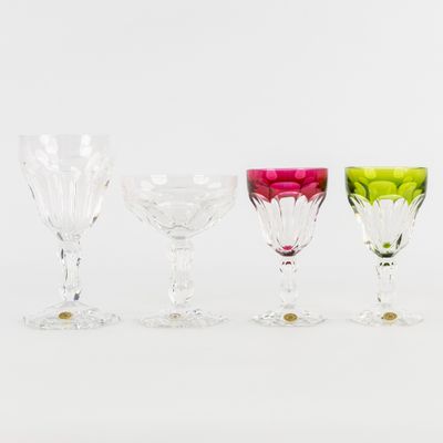 quatre verres à vin de couleurs différentes sont alignés sur une surface blanche