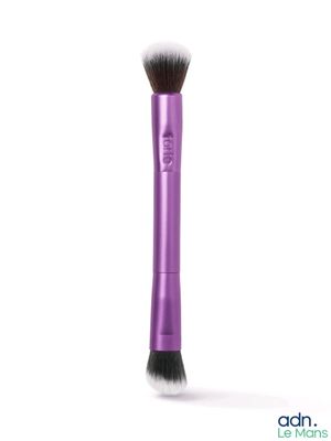 un gros plan d'un pinceau de maquillage violet sur fond blanc