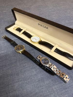 deux montres sont posées dans une boîte sur une surface bleue