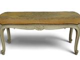 an old bench with a yellow upholstered seat on it