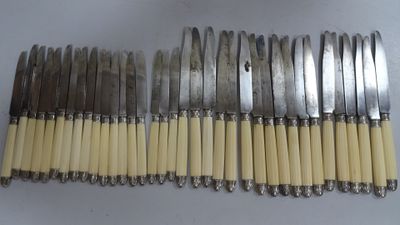 six fourchettes et un couteau sont alignés sur une table