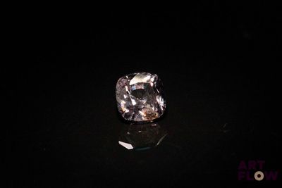 a diamond in the dark with a reflection on the ground