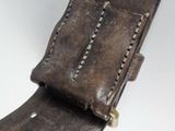 leather watch strap with stitching and rivets on a white background