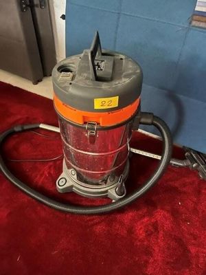 an orange and gray vacuum cleaner sitting on a red carpet