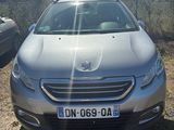 La voiture est garée au bord de la route, au soleil.