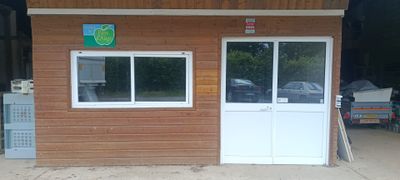 un petit bâtiment en bois avec une porte et des fenêtres blanches
