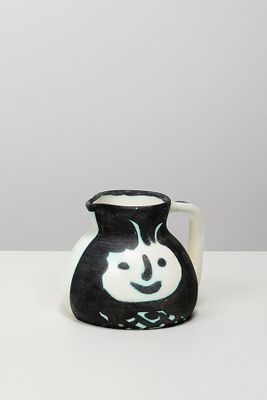 un vase noir et blanc sur lequel est peint un smiley