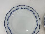three blue and white plates on a table with a white background