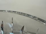 a glass bowl filled with forks and knives on a table