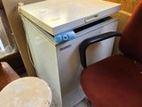 une petite table avec une chaise à côté d'un petit réfrigérateur