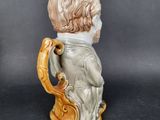 a ceramic figurine of a boy holding a mug