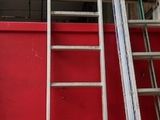 deux échelles situées à côté d'une porte rouge