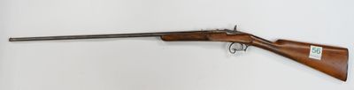 a rifle mounted on a wall in a room with a white wall