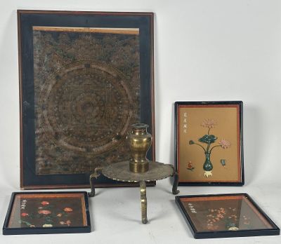 trois photos encadrées posées sur une table, avec un vase et une lampe