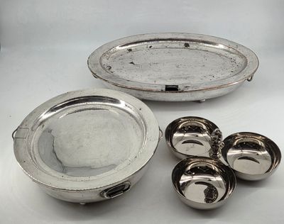 a silver plate with four bowls and four spoons next to it