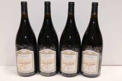 quatre bouteilles de vin sont alignées sur une table