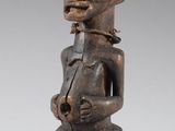 une statue en bois d'une femme avec un chapeau sur la tête