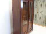 a wooden cabinet with a glass door in a room