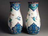 une paire de vases ornés d'oiseaux et de fleurs sur fond gris