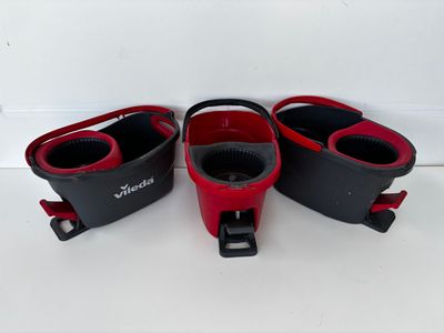 three pairs of red and black shoes are on a white surface