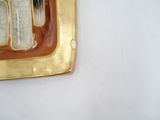 a gold plate with a knife and fork on it