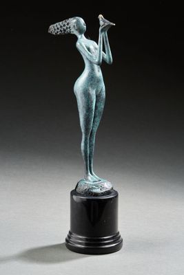 une statue en bronze représentant une femme tenant un oiseau dans la main
