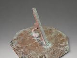 a bronze sundial with roman numerals on it