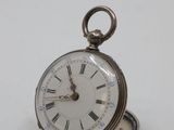 a silver pocket watch with roman numerals on it
