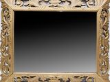 an ornately carved mirror with a black background and a gold frame
