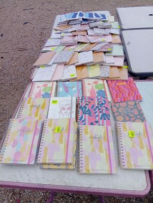 several notebooks are lined up on a table in front of a laptop