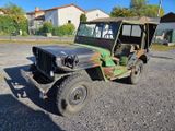 une jeep verte garée sur le gravier
