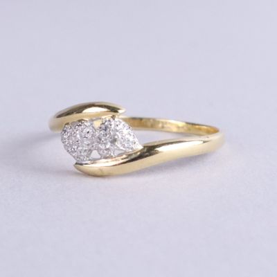 un gros plan d'une bague en or surmontée de deux diamants