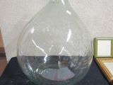 a large glass vase sitting on a table next to a picture frame
