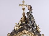 a clock that has a statue on top of it